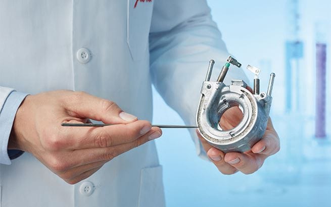 Técnico mostrando pieza con cal en una cafetera